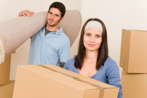 Professional movers carrying boxes through a West London residential street